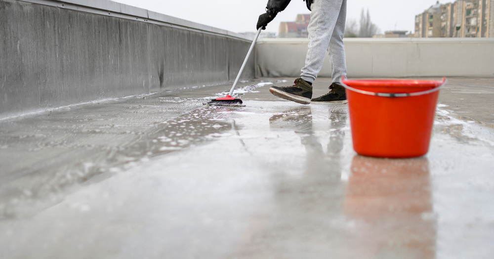 Man acid washing concrete flooring