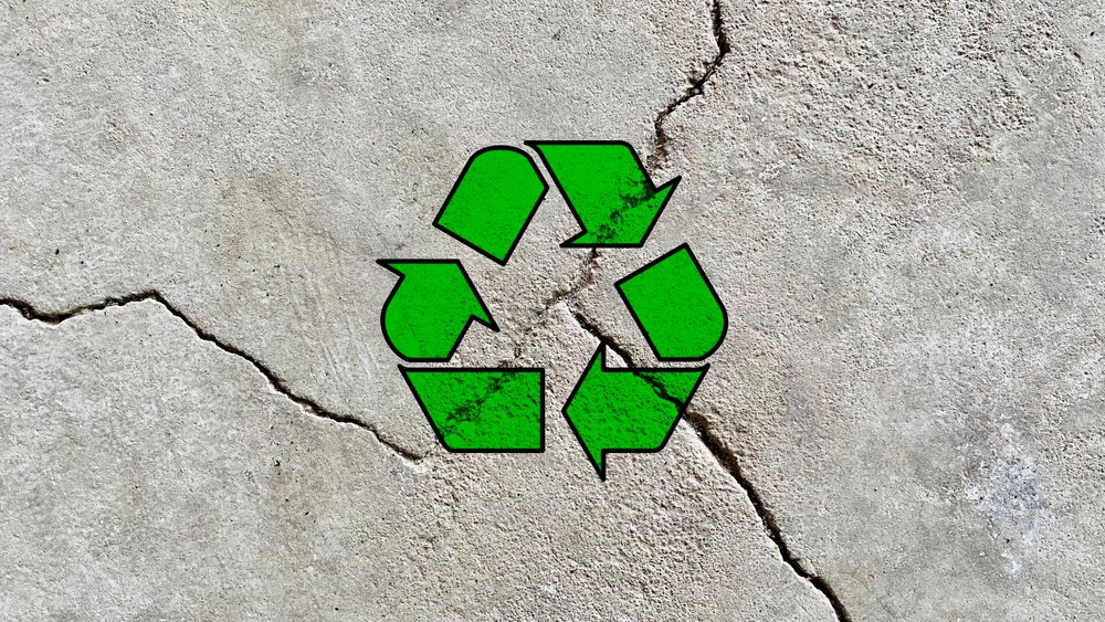 Green,recycle,arrow,icon,on,a,cracked,cement,wall,background,