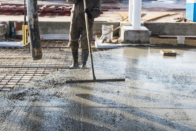 Construction Worker Using Concrete Screed